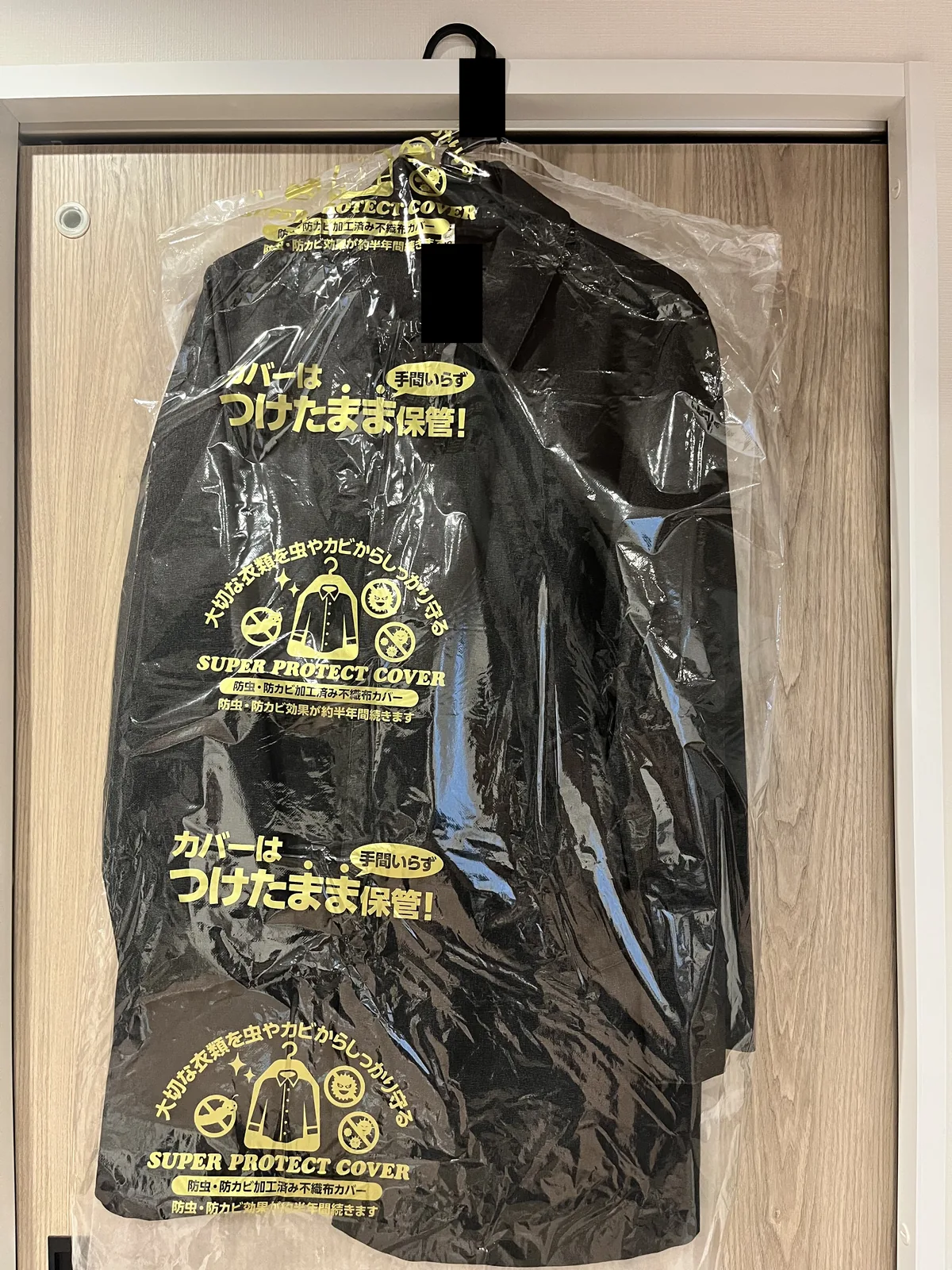 扉にかけた衣類カバー入りの上着