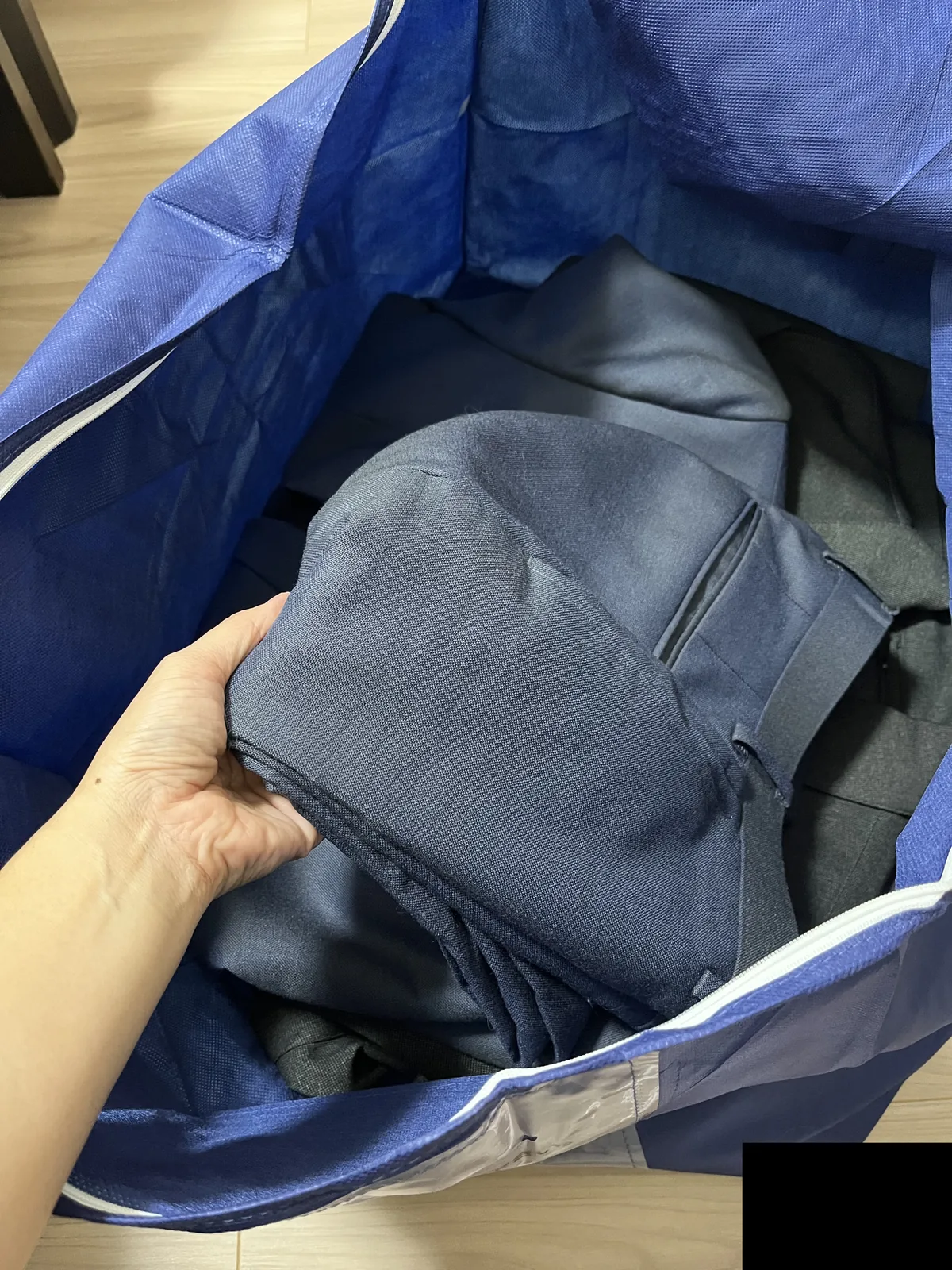 集荷袋に衣類を入れているところ