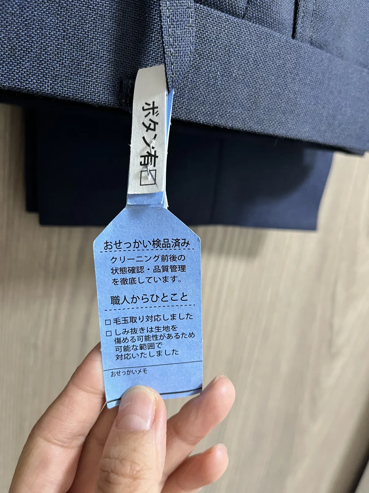 戻ってきた衣類に付いていた「おせっかい検品済み」のタグ